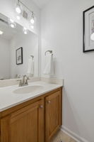 Upstairs bonus half bath with solid oak cabinets and new brushed nickel fixtures.