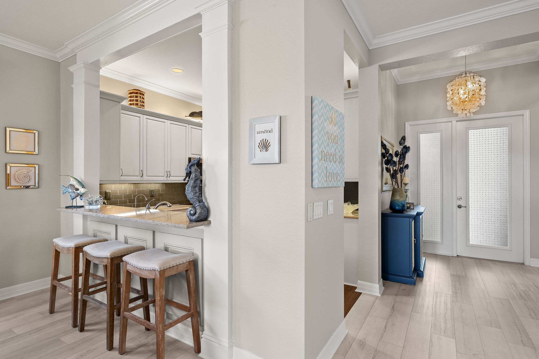 Foyer and bar seating for 3 captured in this shot. Easily pass food from kitchen to dining room! Note the custom millwork beyond the bar stools!