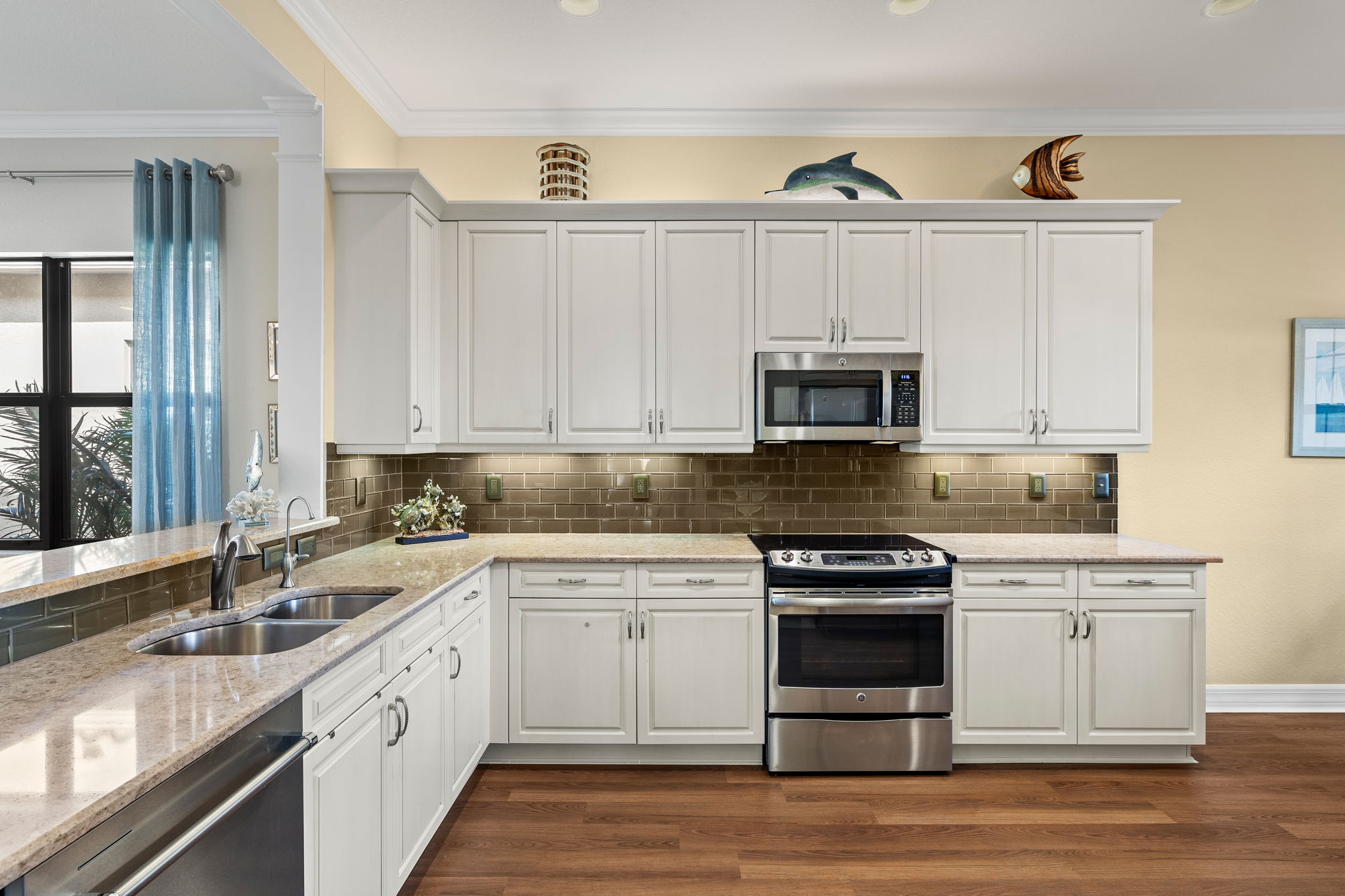 Kitchen view from foyer...crown molding, beautiful backsplash, light and bright!