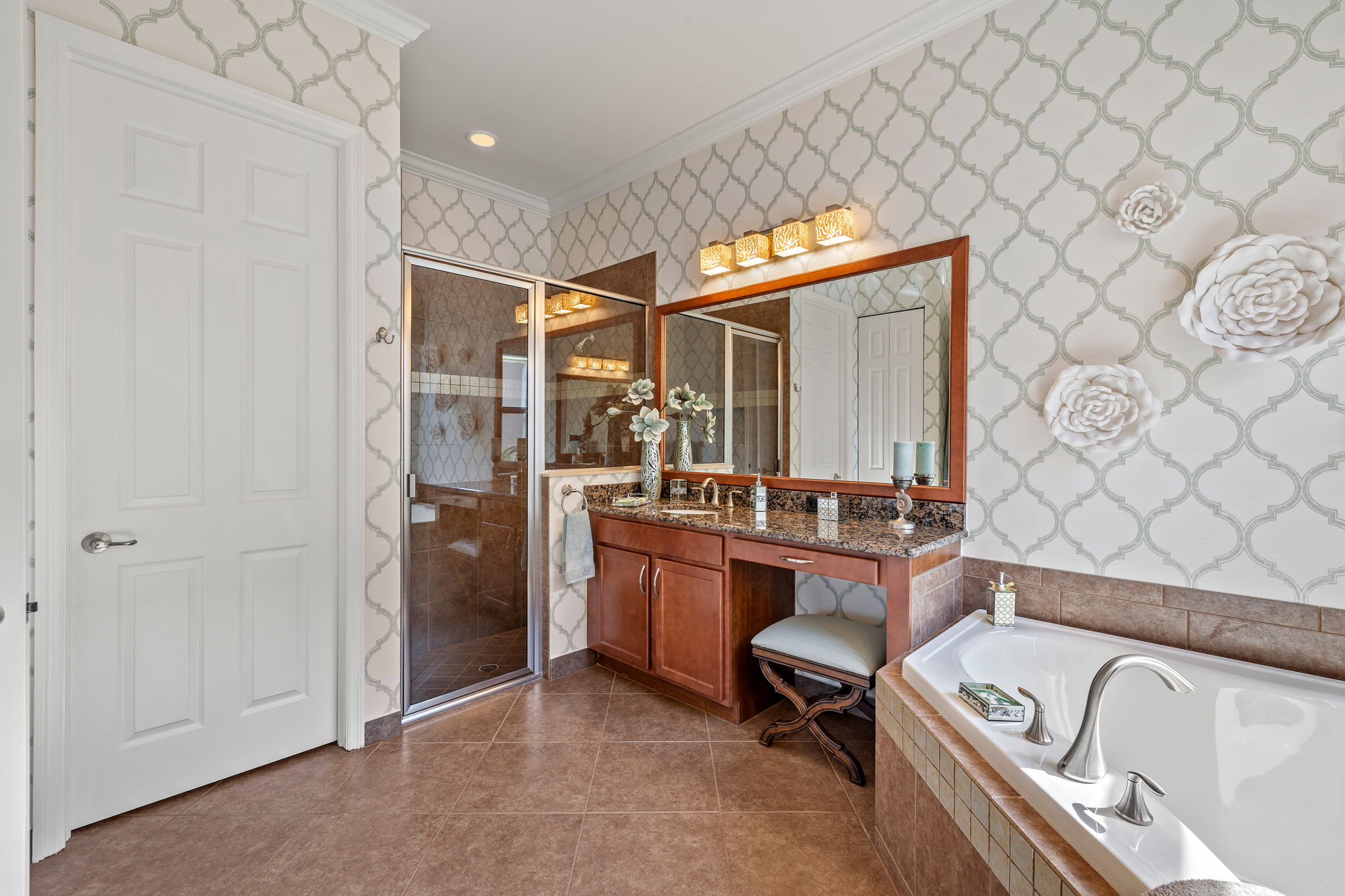 Spacious walk-in shower, crown molding, tasteful wallpaper, ceramic flooring.