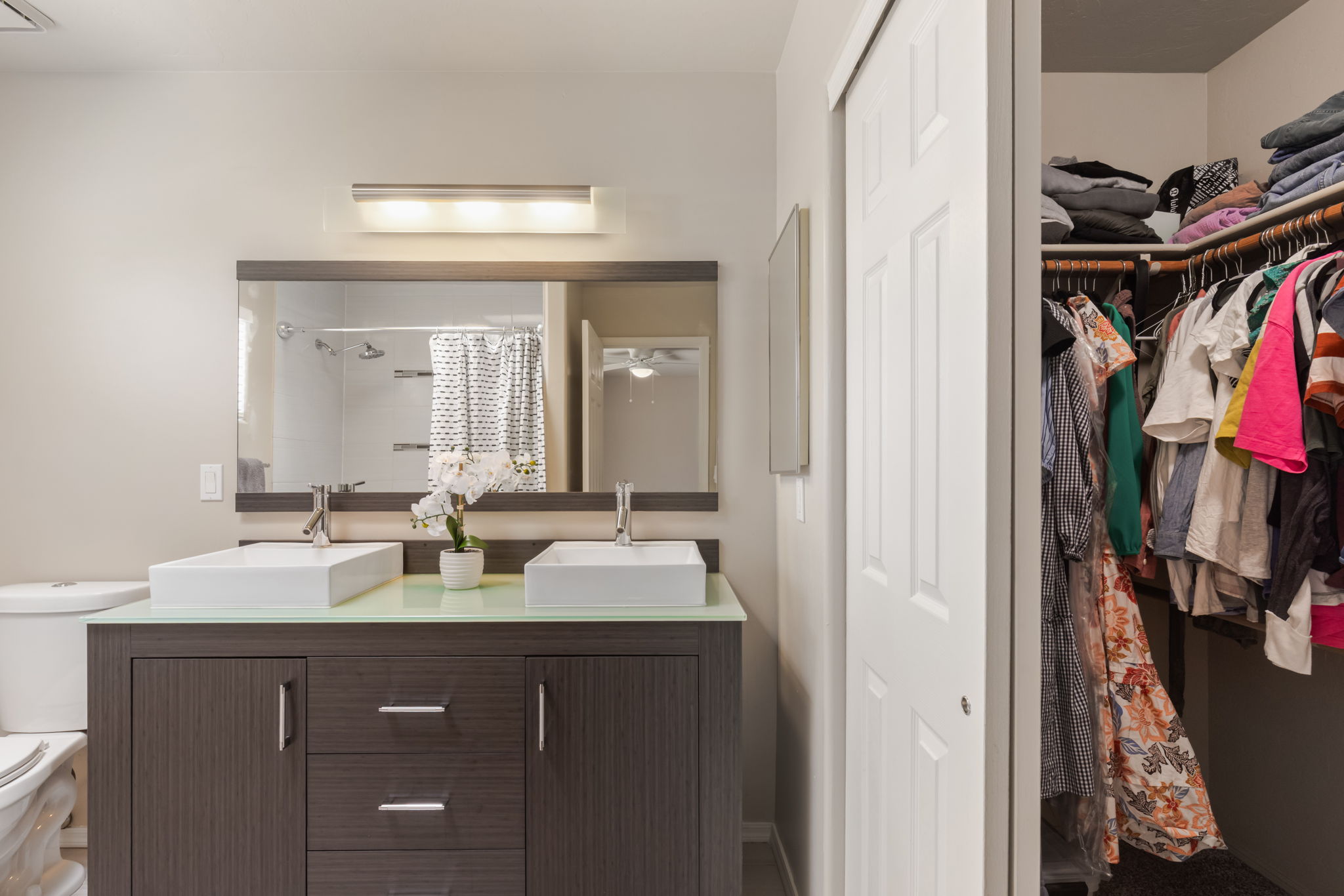 Primary Bathroom with dual raised sink vanity/ view to large closet