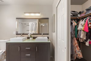 Primary Bathroom with dual raised sink vanity/ view to large closet