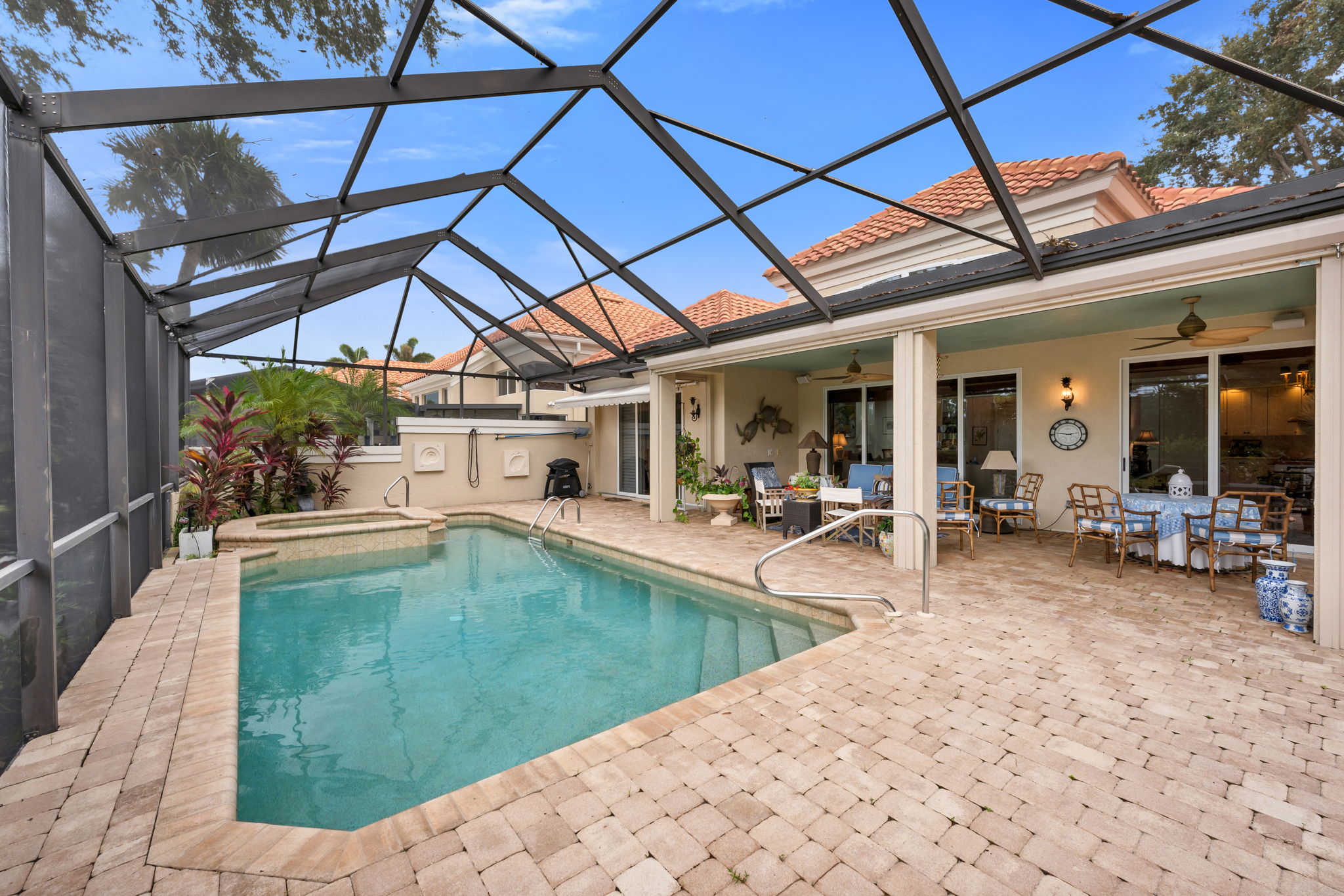 Pool area has paver surrounds, screen enclosure, grill area with outdoor shower. Plenty of area for lounging in the sun!