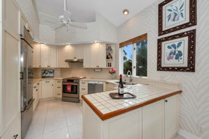 Updated kitchen offers stainless steel appliances, Shaker style cabinetry, quartz and tile countertops