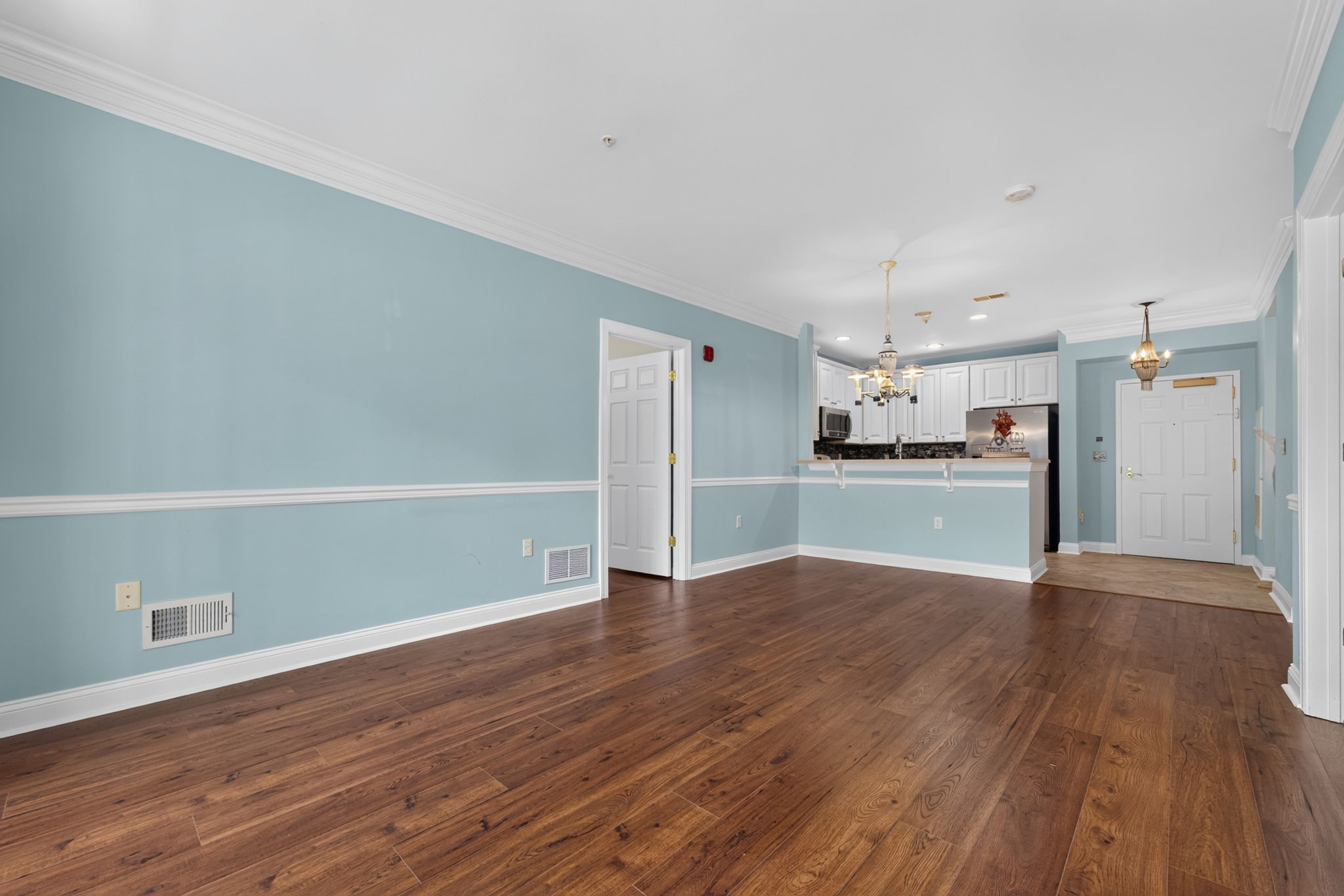 Elegant crown moldings enhance the open floor plan of the formal dining and living area. Newer LVT flooring flows seamlessly through these rooms.