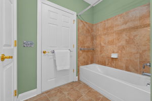 Bedroom 2 provides access to a Jack-and-Jill bath featuring a vanity, medicine cabinet, linen closet, tub-shower with a tile surround, and ceramic tile flooring.