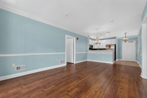 Elegant crown moldings enhance the open floor plan of the formal dining and living area. Newer LVT flooring flows seamlessly through these rooms.