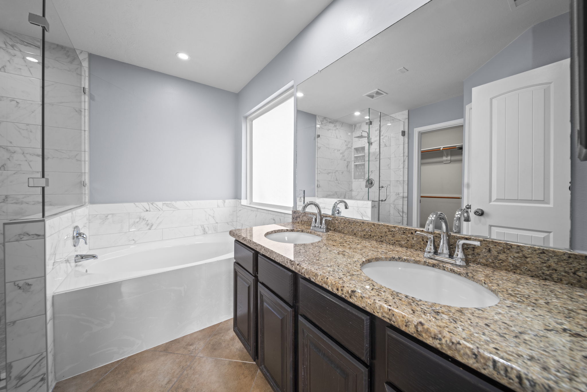 Primary bathroom with tile flooring, recessed lighting, Granite countertops & double sinks!