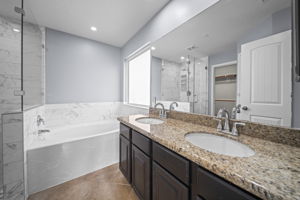 Primary bathroom with tile flooring, recessed lighting, Granite countertops & double sinks!