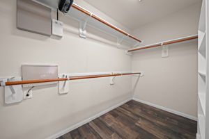 Primary walk-in closet with built-ins & wood-look tile flooring!