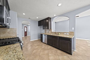 Kitchen is open to the living area with arched entryways and raised bar seating!