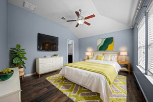 Primary bedroom with high ceilings, a ceiling fan, 2" blinds, wood-look tile flooring, 2" blinds and an en-suite.