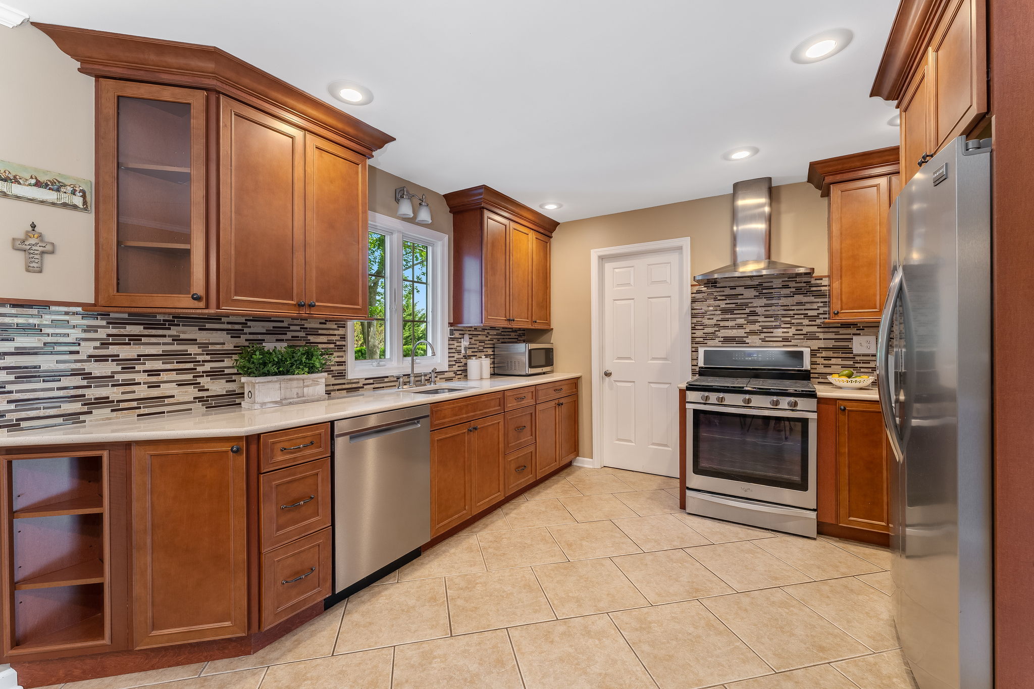 A 2017 kitchen addition features abundant maple cabinetry with soft-close feature, center island with storage, double-door pantry. Stainless steel appliances include Whirlpool 5 burner range, Broan Exhaust hood, Frigidaire Gallery Refrigerator, Whirlpool dishwasher.