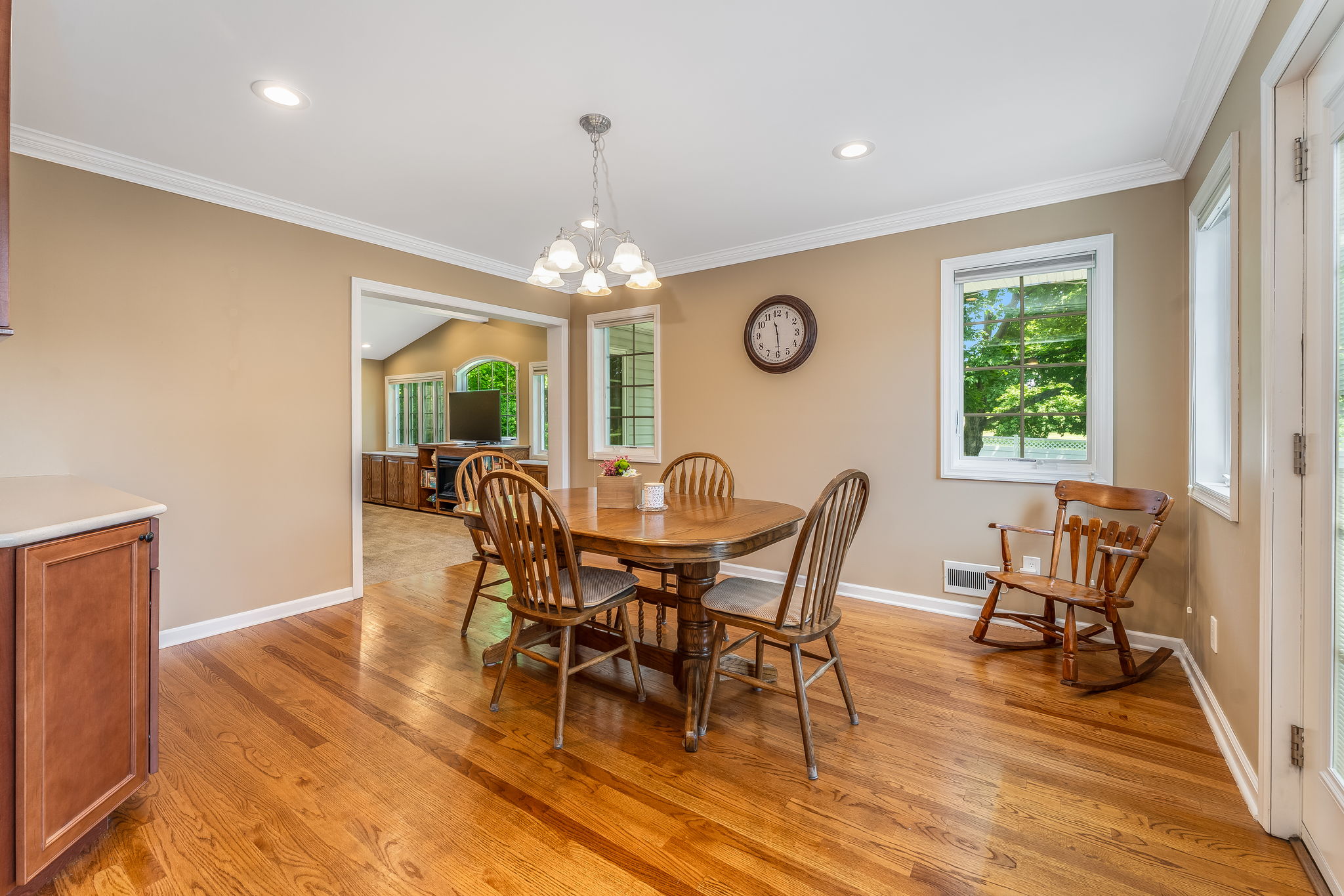 Recessed lighting, crown moulding, hardwood floor. Patio door with enclosed blinds opens to a spacious, maintenance-free deck overlooking the private fenced yard, ideal for outdoor enjoyment.