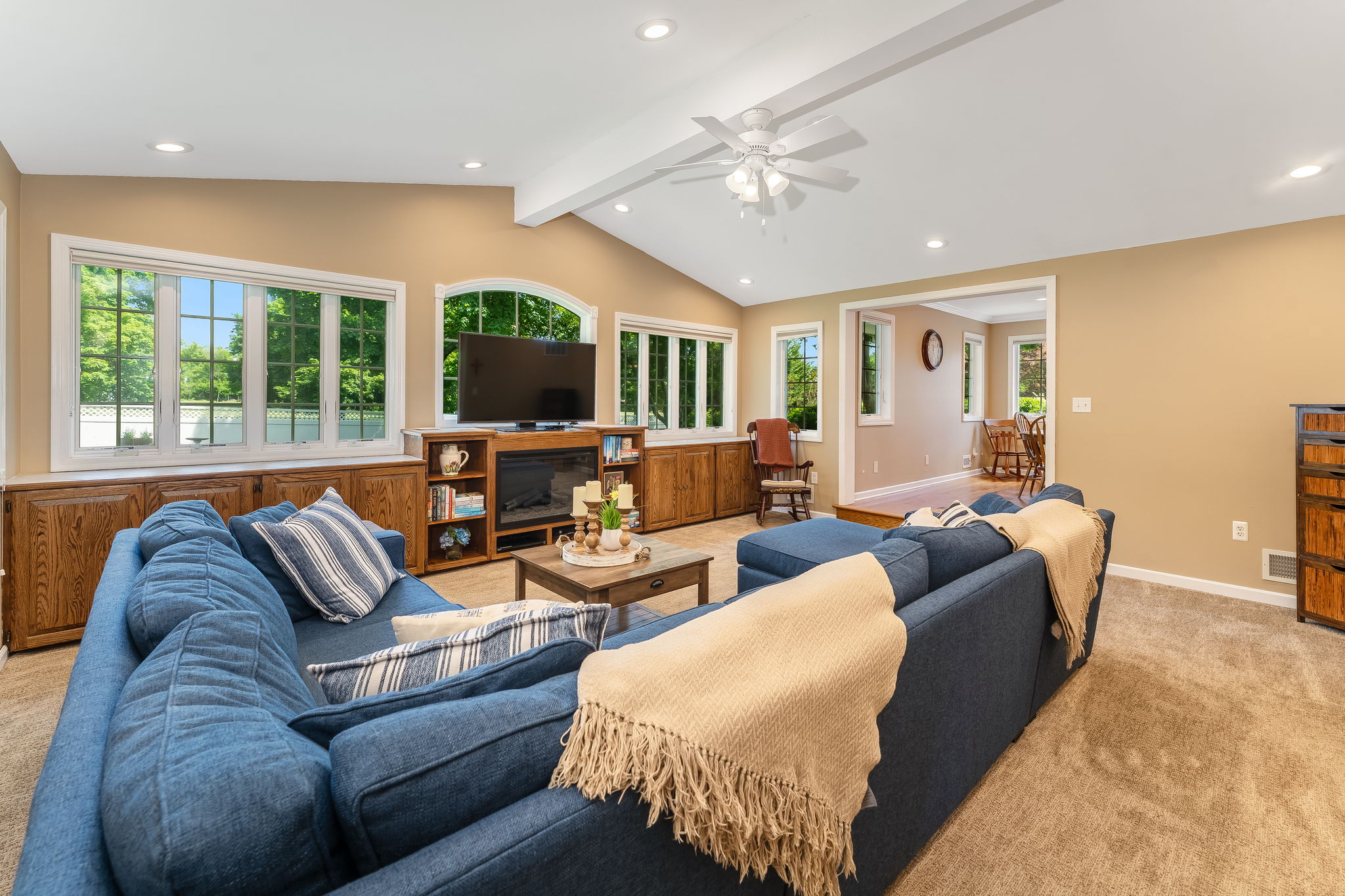 Great room addition showcases a dramatic wall of windows, volume ceiling, and custom built-ins for seamless organization.
