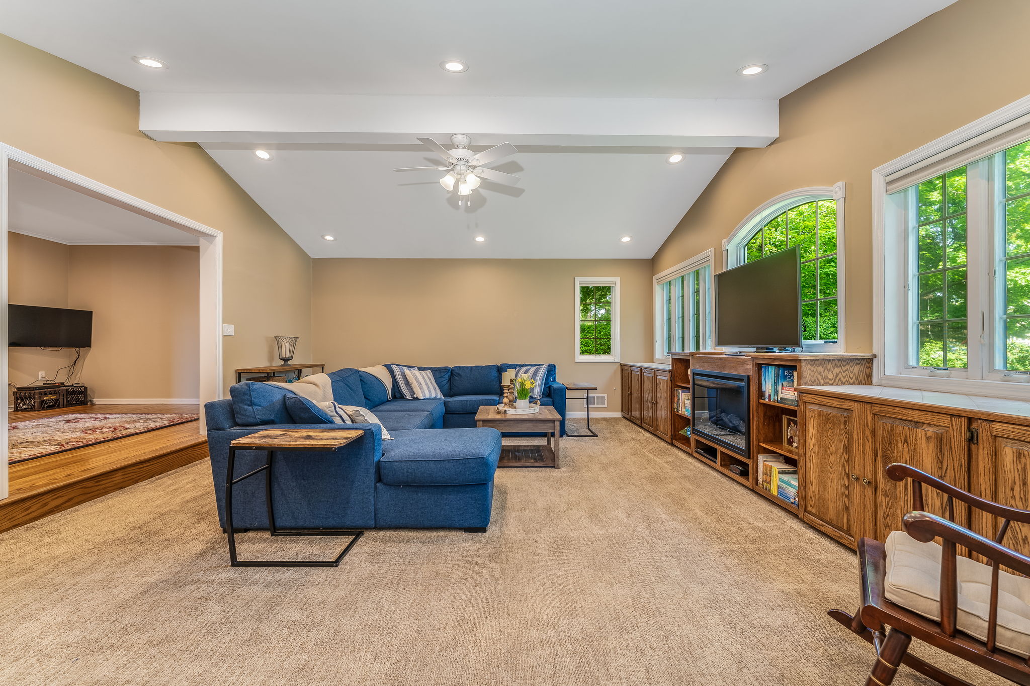 Great room addition showcases a dramatic wall of windows, volume ceiling, and custom built-ins for seamless organization.