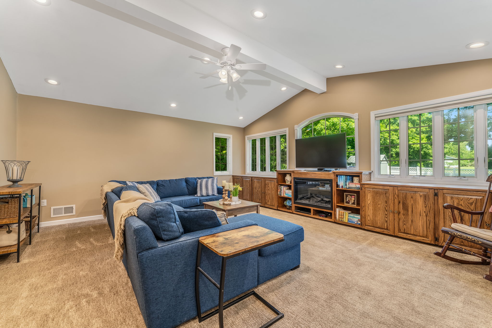 Great room addition showcases a dramatic wall of windows, volume ceiling, and custom built-ins for seamless organization.