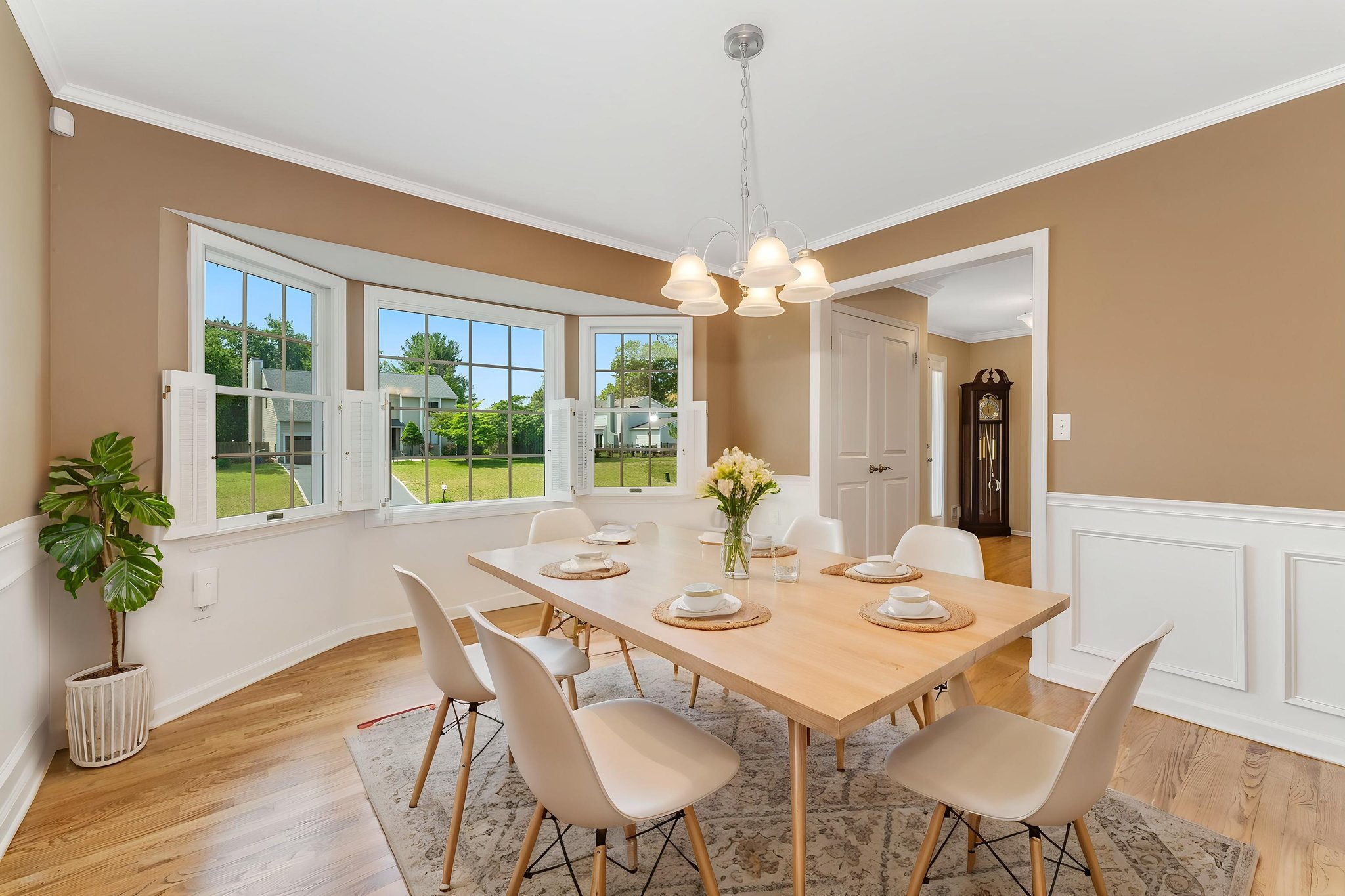 virtually staged-Crown, chairrail and picture mouldings, bay windows, shutters, Chrome and glass 5-light fixture, hardwood floor