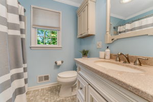 Main Bath Updated hall bath features crown moulding, vanity with undermount sink, tub-shower with insert, Kohler toilet, ceramic tile floor.