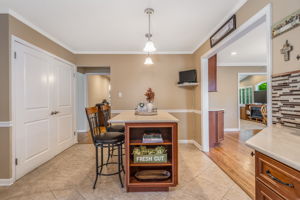Breakfast room offers casual dining with a built-in buffet, wine fridge, and glass-front cabinetry,storing tableware within easy reach.