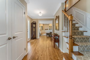 Entry door with sidelites, crown moulding, double door closet, turned staircase, hardwood floor.