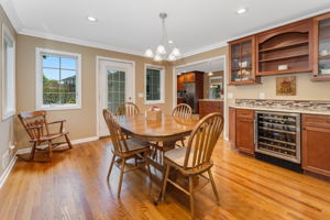 Breakfast room offers casual dining with a built-in buffet, wine fridge, and glass-front cabinetry,storing tableware within easy reach.