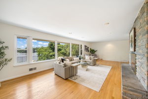 Expansive living room w/fireplace overlooks lake