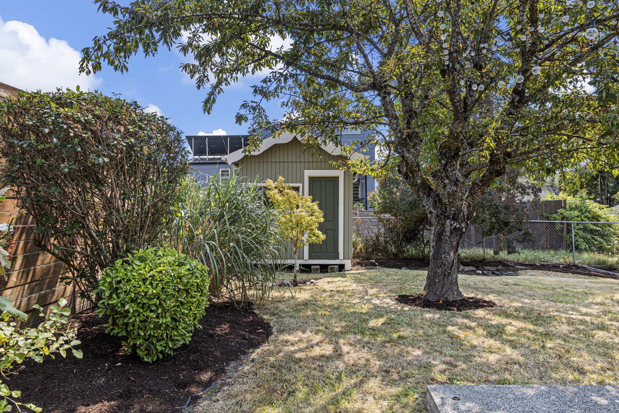 Even the back corner feels considered—the detached shed sits beneath mature canopy, with a front window for daylight and room for secure, dry bike storage, yard gear or potential studio/workspace use.