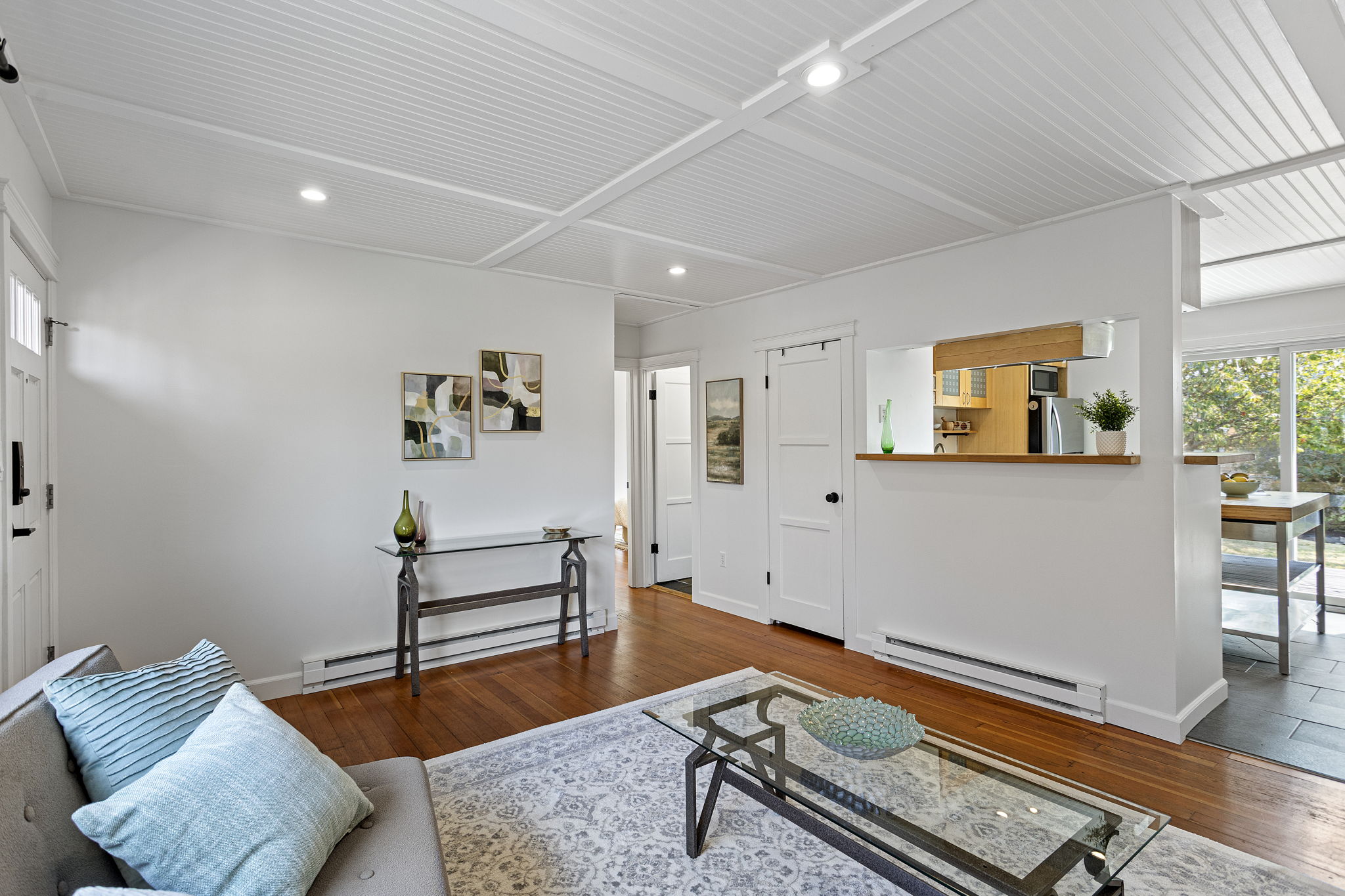 The kitchen stays defined without feeling cut off—the pass-through keeps conversation and sightlines moving across the main living space.