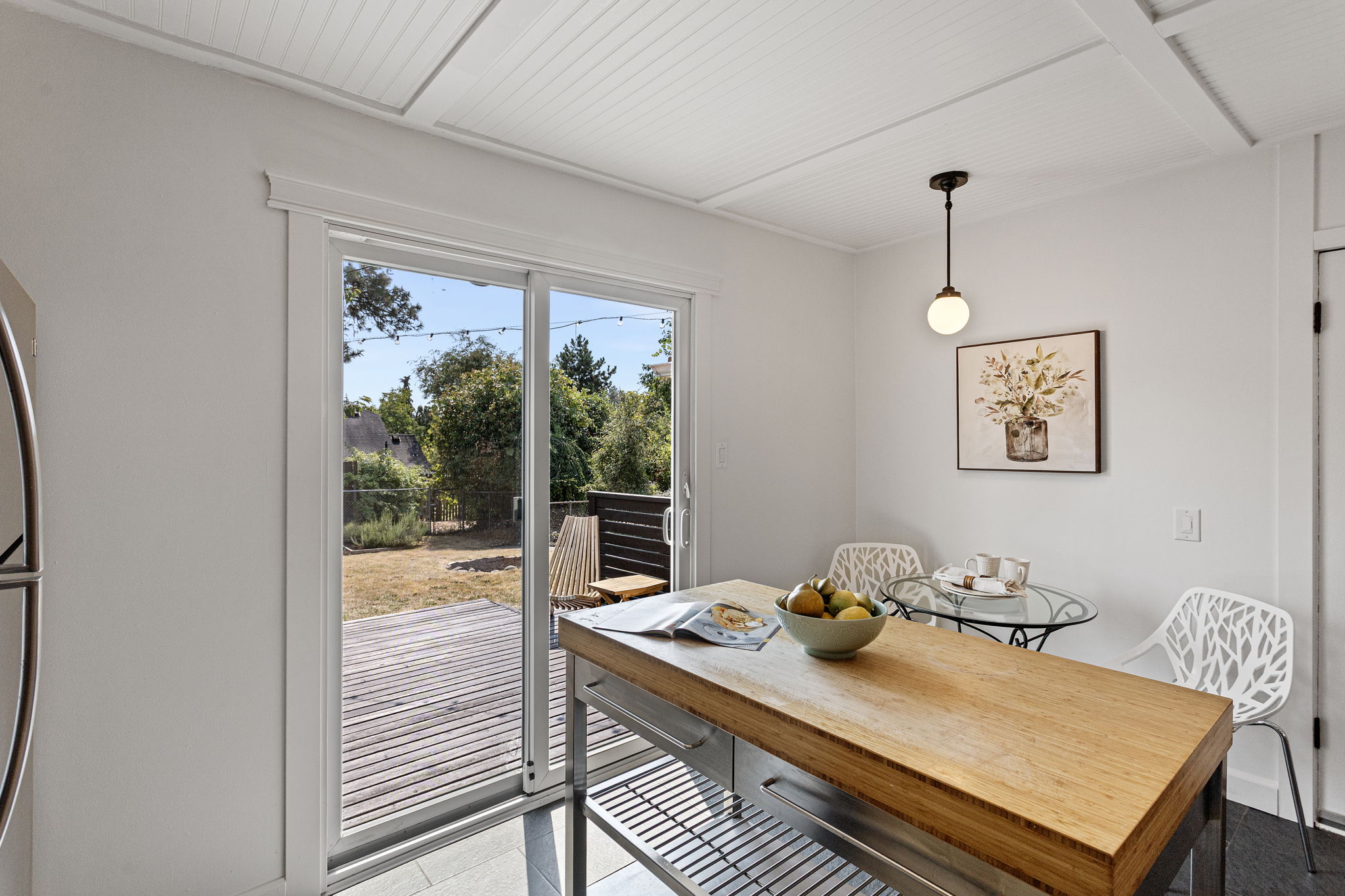 The kitchen ends at the slider. From here, the house hands off to the deck, yard and everything beyond.