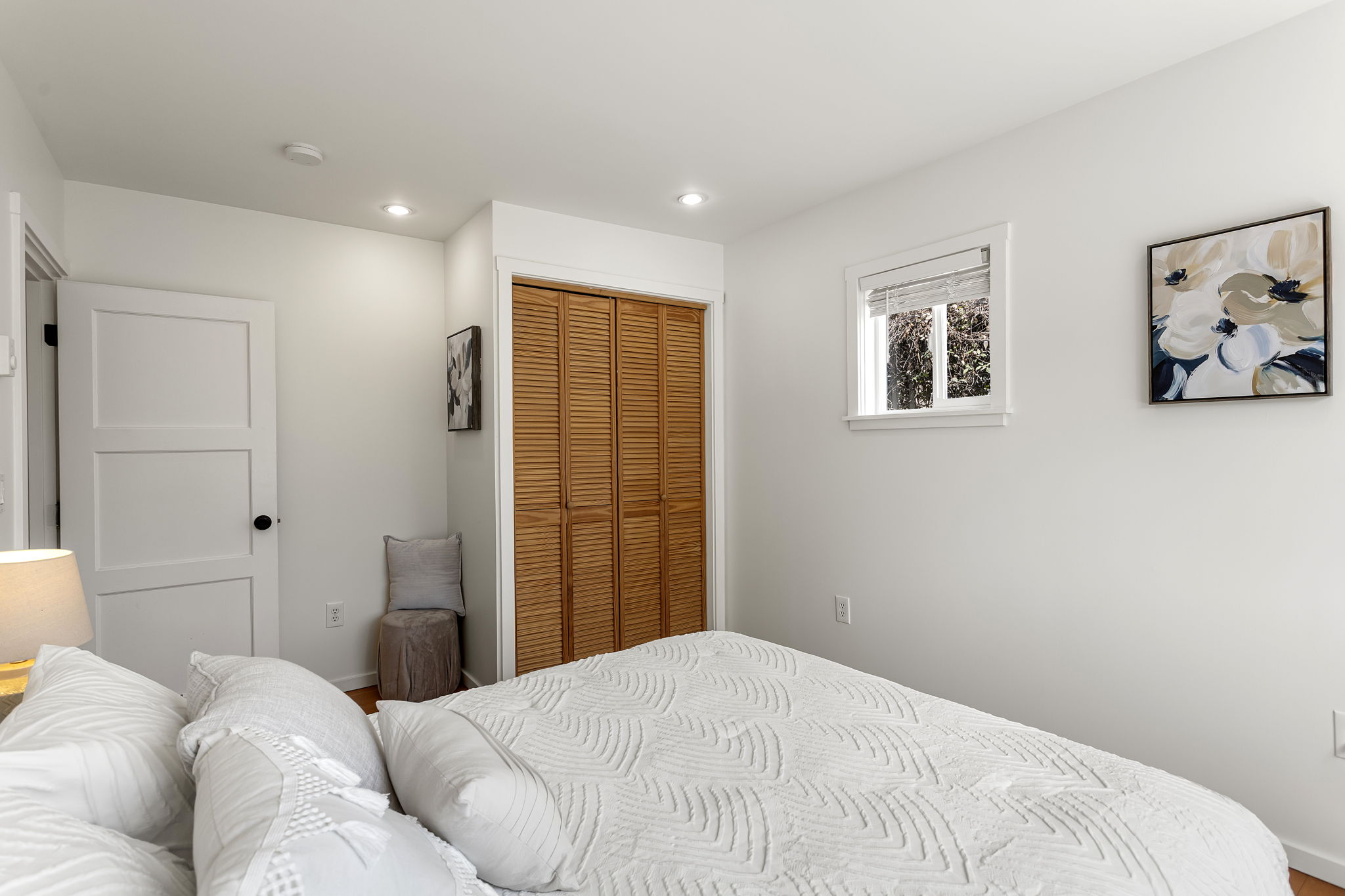 This angle shows the room’s proportions best: the bed fits comfortably, with clear circulation, usable wall space and morning light from the east-facing window.