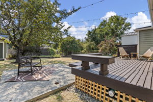 Out back, the lot breaks into places to actually use it: deck, separate patio, open yard and a mature tree tying the whole thing together.