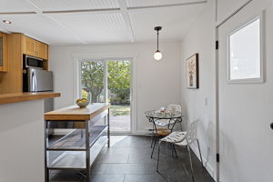 This is the hinge of the house: dining space, extra prep surface, and a sliding door that makes the deck feel like the next room.