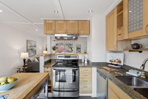 Storage goes vertical: full-height cabinetry, deep drawers, open cubbies and glass-front uppers put nearly every inch to work.