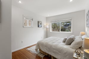 The main bedroom looks south across the backyard—a peaceful vista of mature trees, open sky and the grounds beyond.