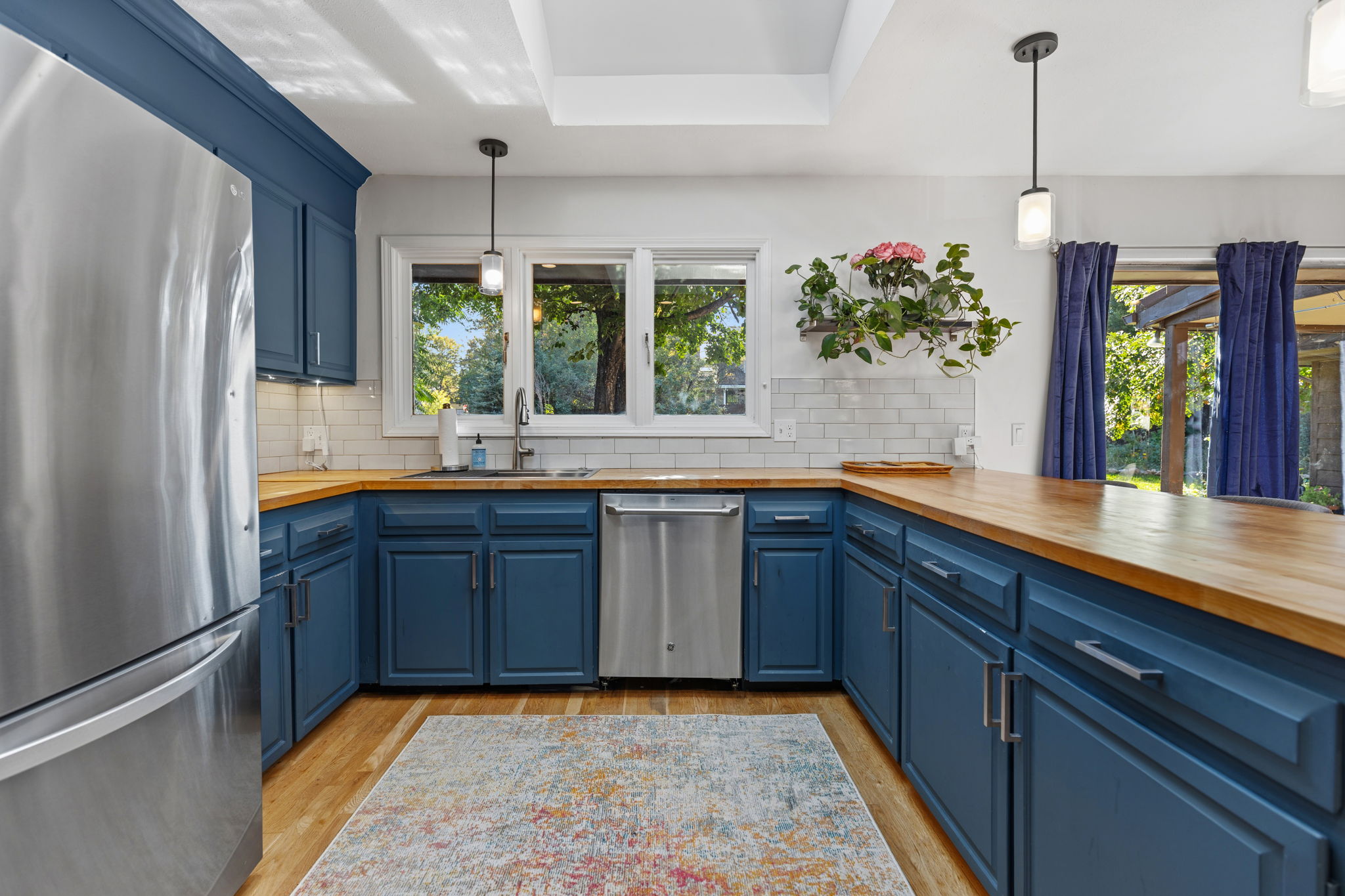 Functional kitchen layout with a tile backsplash, window overlooking the yard, and ample counter space