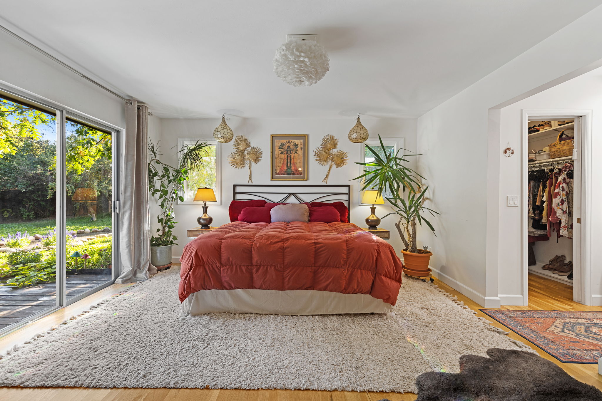 Main view of the primary bedroom showing the layout, patio doors to backyard, and walk-in closet