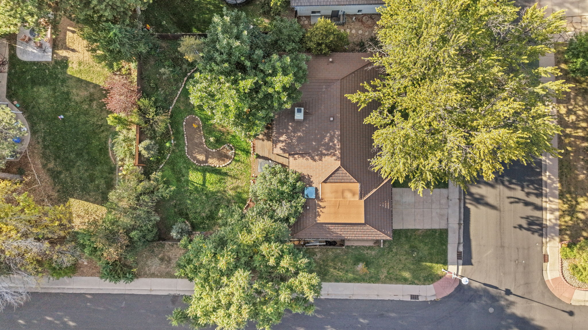Aerial drone view highlighting the corner lot location, large shade trees, and surrounding neighborhood.