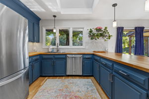 Functional kitchen layout with a tile backsplash, window overlooking the yard, and ample counter space