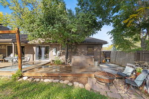 Spacious back deck featuring a premium hot tub, seating area, and mature trees