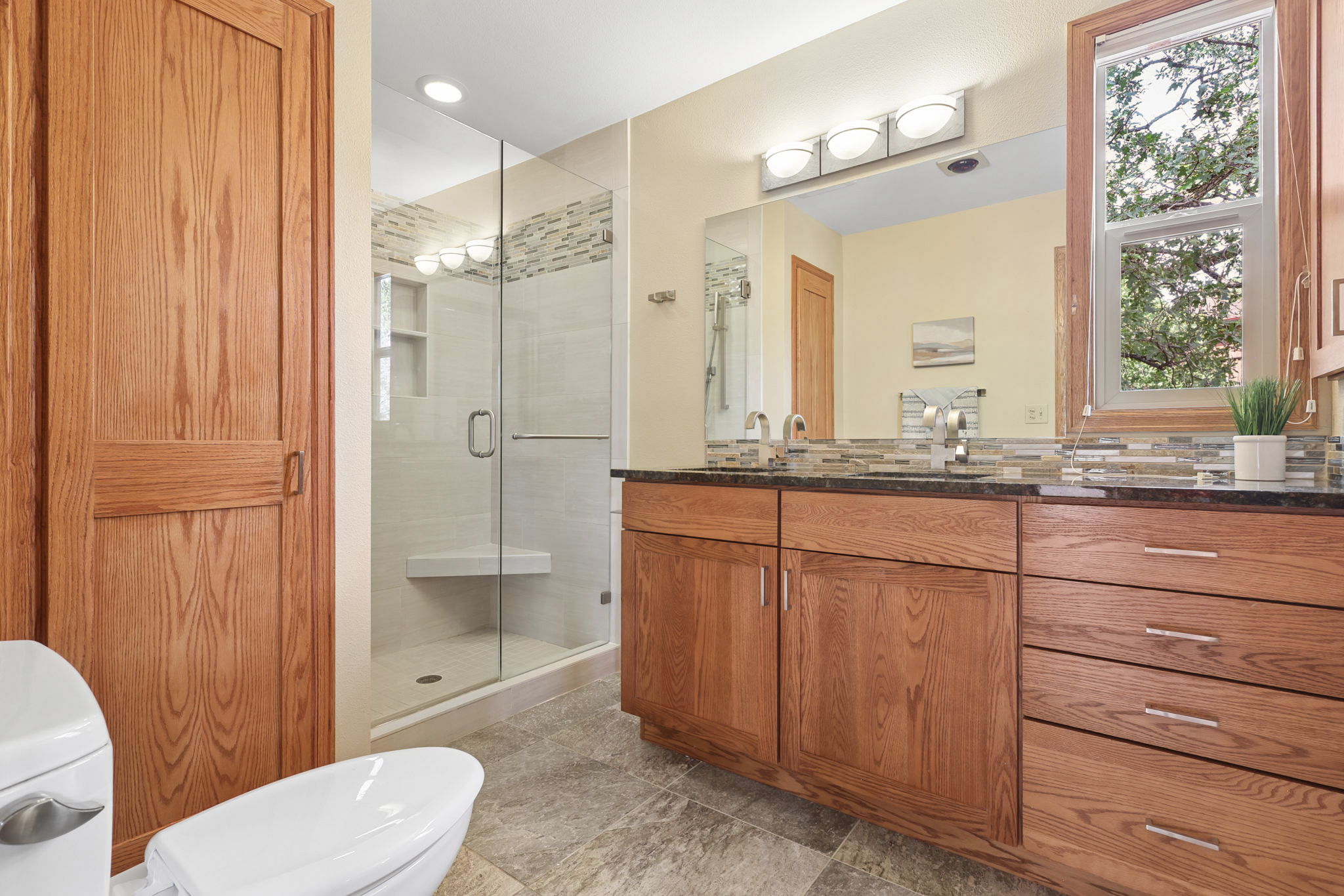 Primary bath remodeled with granite and stone flooring.