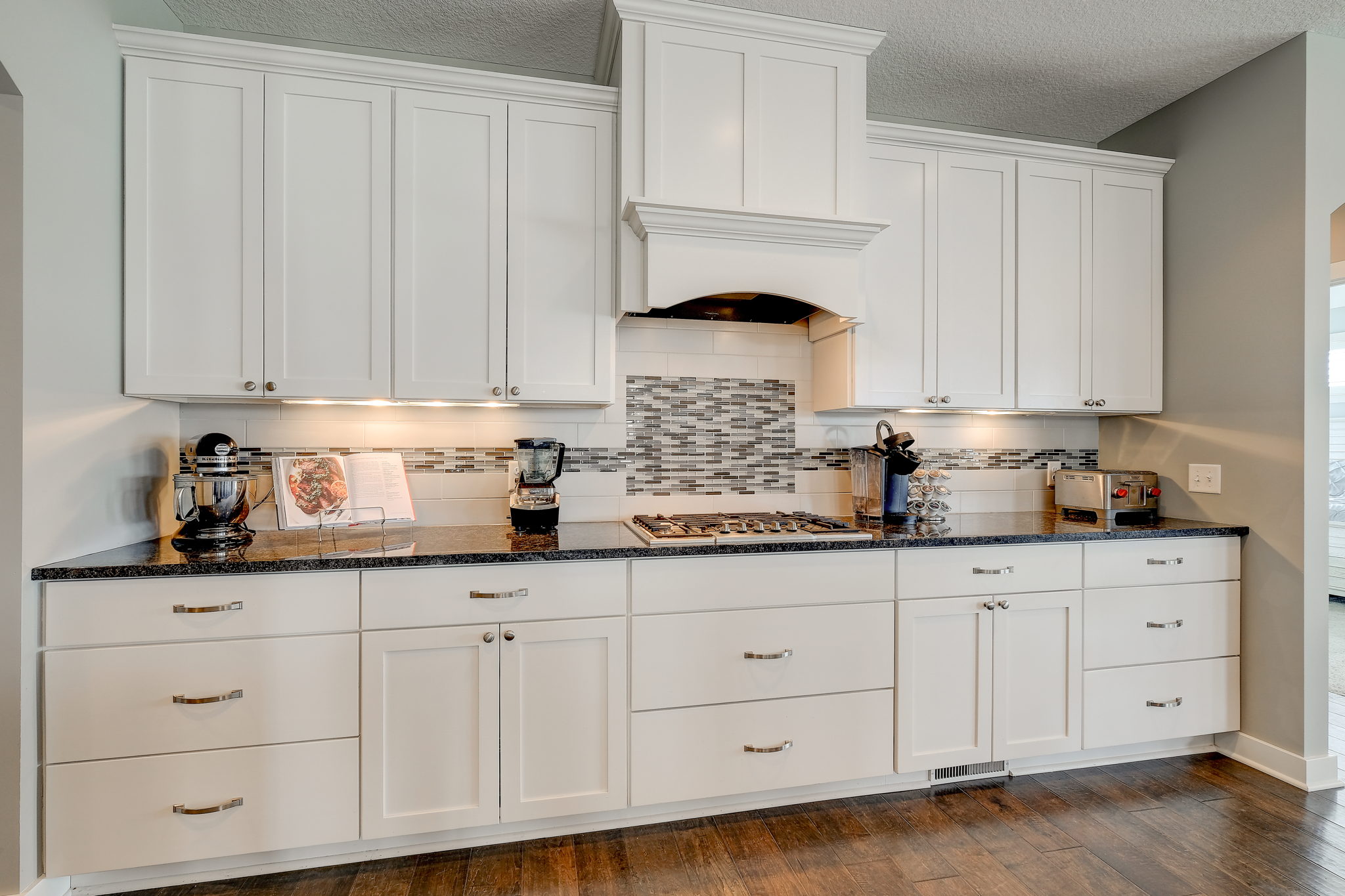 Kitchen With Abundant Cabinets, Granite Counters And Tiled Backsplash