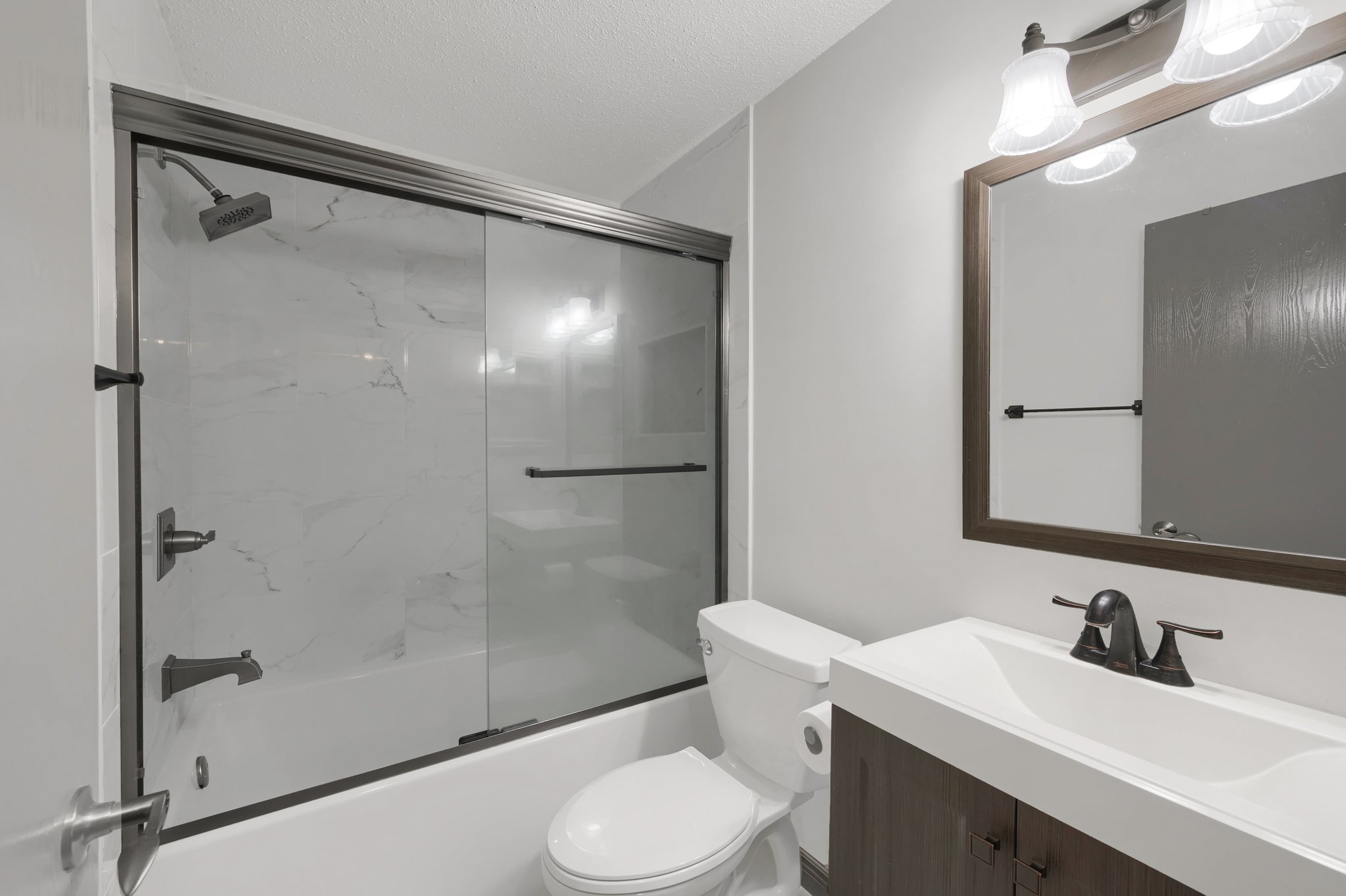Recently updated full guest bathroom, fully remodeled in July of 2022, offering a new vanity, fixtures, tub, and ceramic tile shower and floors.