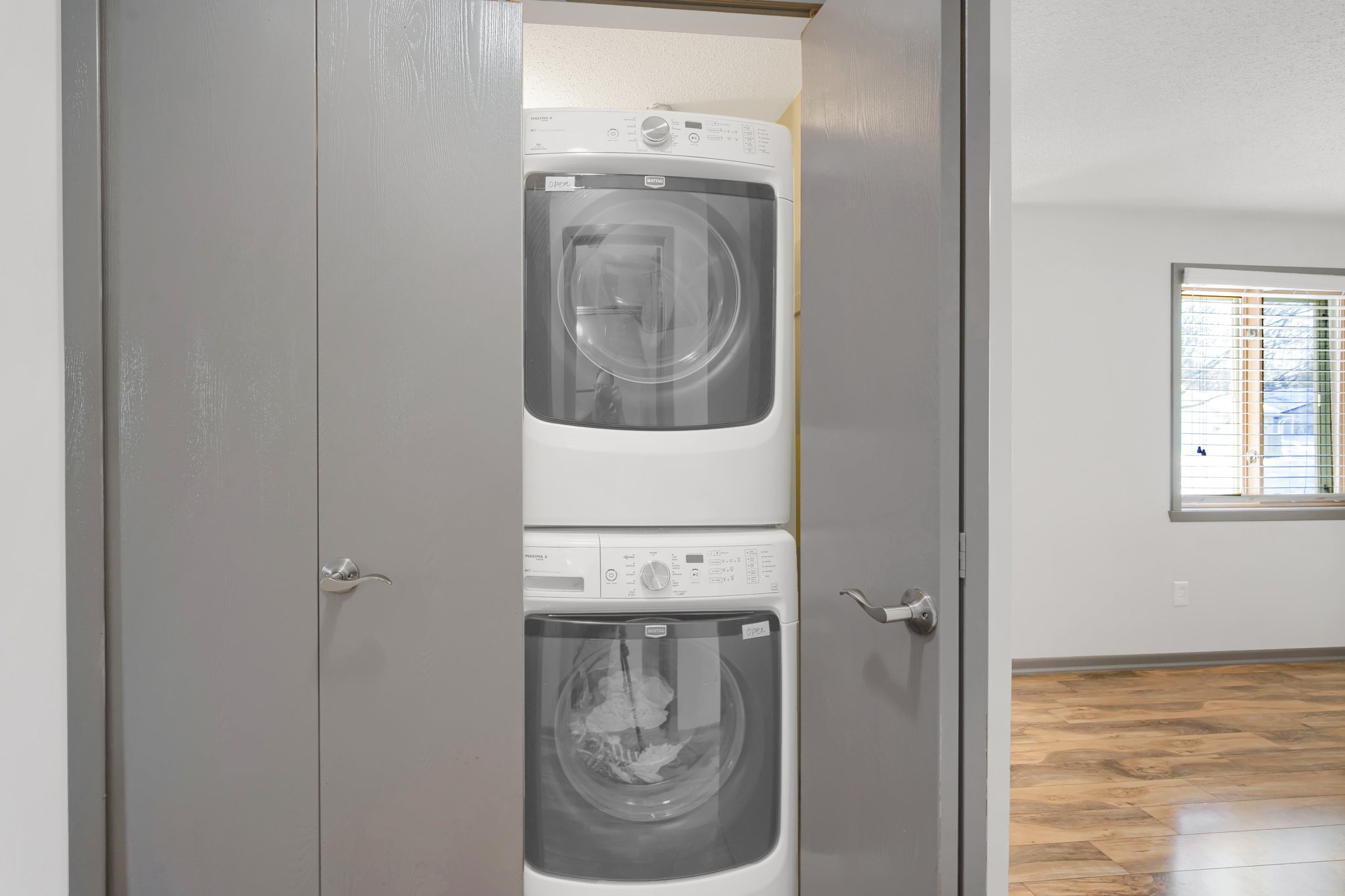 The laundry closet boasts an efficient layout, including a washer and dryer, and a utility sink located right next to it for added ease.