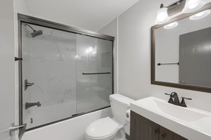 Recently updated full guest bathroom, fully remodeled in July of 2022, offering a new vanity, fixtures, tub, and ceramic tile shower and floors.