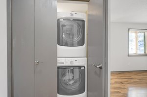 The laundry closet boasts an efficient layout, including a washer and dryer, and a utility sink located right next to it for added ease.