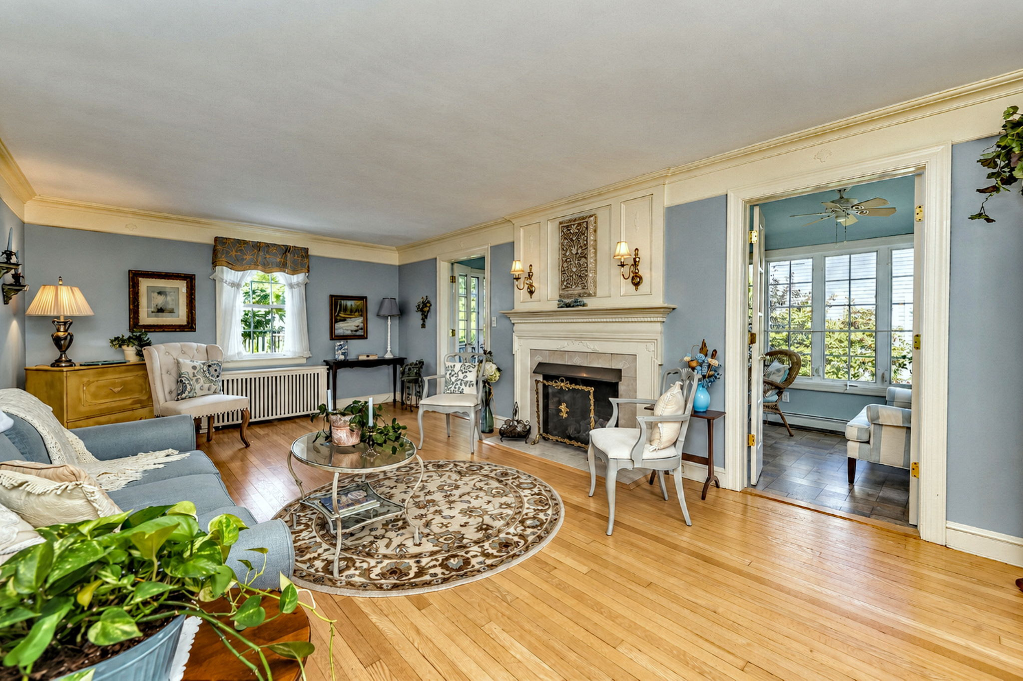 Spacious Living Room with Hardwood Floors and a Cozy Fireplace. Perfect for Everyday Comfort or Entertaining Guests.
