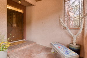 Front Door entry with custom metal gate and welcoming mosaic tile bench