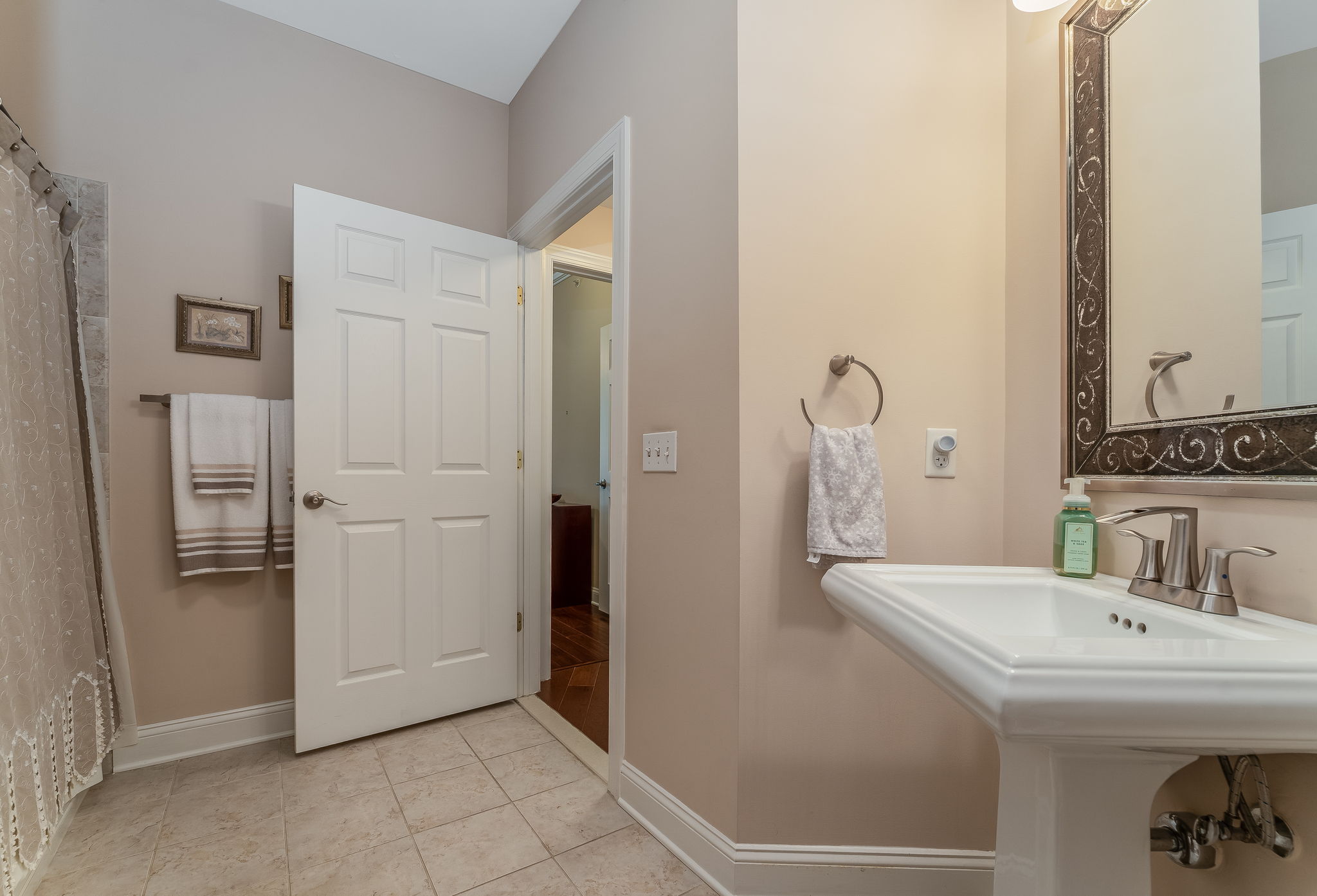 Full Hall Bath The hall bath features a pedestal sink, tub-shower in tile surround and ceramic tile floor.