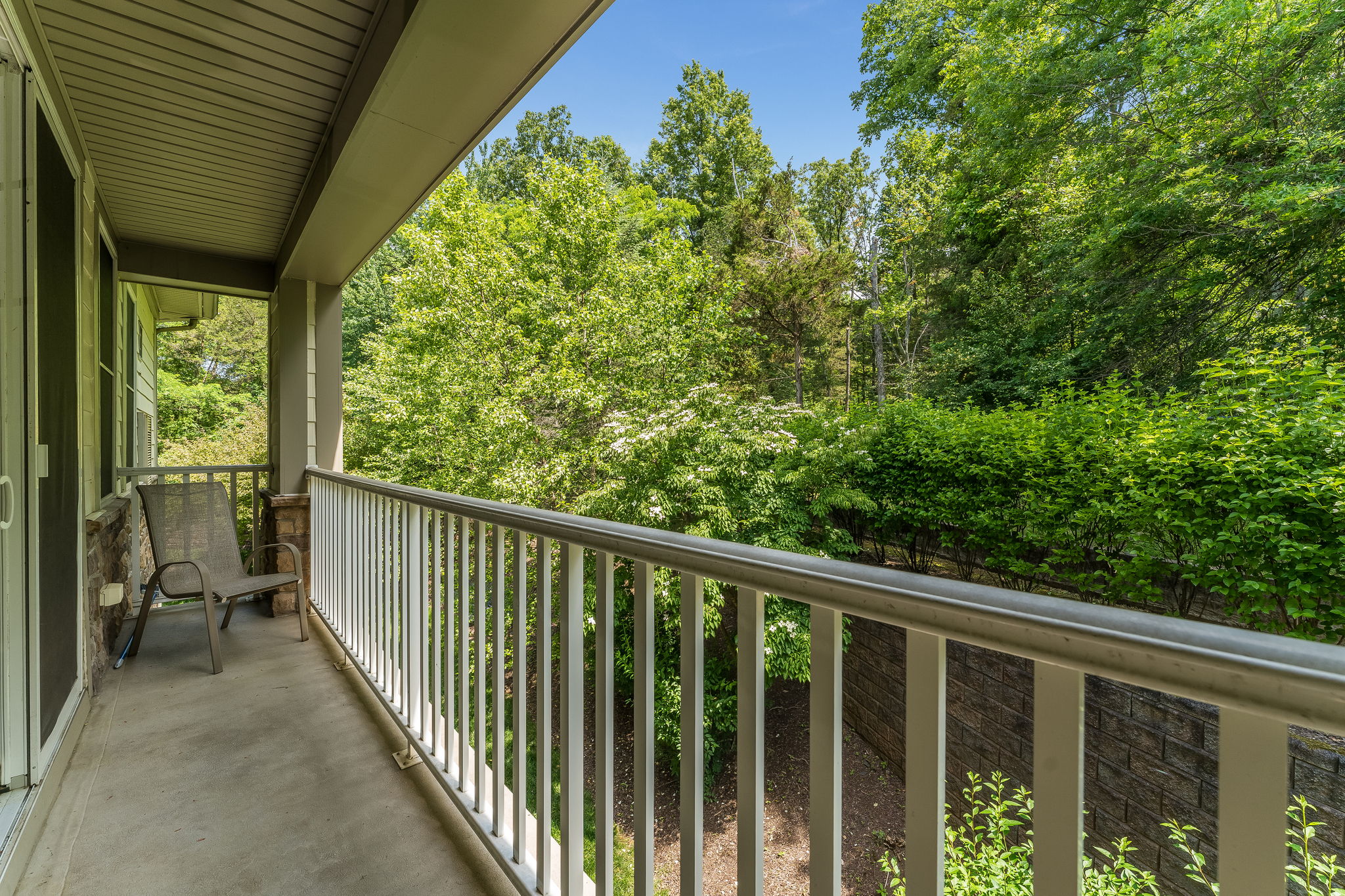 Balcony A full wall of windows & sliding doors fill the space w natural light & open to a private balcony overlooking a peaceful wooded setting.